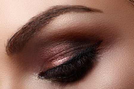 Beautiful macro shot of female eye with extreme long eyelashes and black liner makeup. Perfect shape make-up and long lashes. Cosmetics and make-up. Closeup macro shot of fashion eyes visageの写真素材
