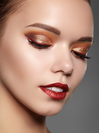 Beautiful Woman with Professional Makeup. Luxury Style Eye Make-up, Perfect Eyebrows, Shine Skin. Bright Fashion Look. Gold Color of Eyeshadows. Christmas Celebrate Imageの写真素材