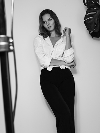 Attractive Sensual Woman is Posing in White Shirt. Black and White Cinematic Portrait with Cute Emotions.の写真素材