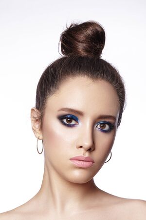 Beautiful Brunette Woman with Fashion Makeup and Bun Hairstyle. Celebrate Style Eye Make-up. Bright Fashion Look.の写真素材