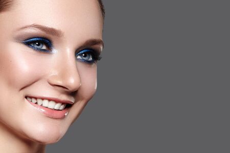 Beautiful Woman with Professional Blue Makeup. Celebrate Style Eye Make-up and Shine Skin. Smiling Fashion Model. Beautifil Happy Smileの写真素材