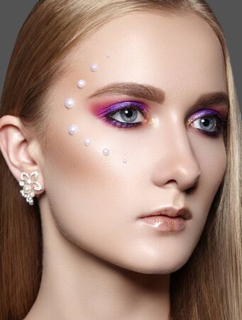 Beautiful Woman with Professional Creative Makeup with Perls. Celebrate Style Eye Make-up, Perfect Eyebrows, Shine Skin. Bright Fashion Look. Glow Skin with Shimmerの写真素材