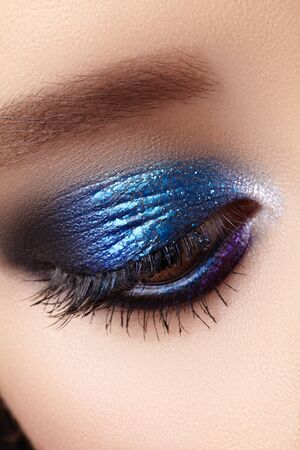 Closeup Macro of Woman Fashion Make-up of Eyes. Glitter Blue Celebrate Makeup, Perfect Color of Eyeshadows. Long Lashes.の写真素材