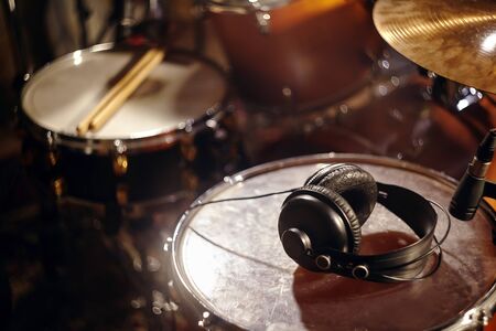 Black Headphones on Studio Drums. Beautiful Closeup Concept of Recording Studio or Concert Hall Tools. Musical Background with Great Lightsの写真素材