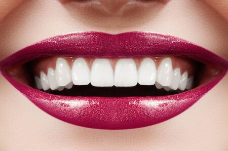 Cropped half face portrait of woman. Closeup Dental Beauty. Beautiful Macro with perfect White Teeth. Sexy Fashion Lips Red Make-up. Whitening Tooth and Wellness Treatmentの写真素材