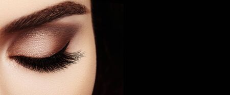 Beautiful Macro Female Eye with Extreme Long Eyelashes and Celebrate Makeup. Perfect Shape Make-up, Fashion Long Lashes. Cosmetics and make-up. Closeup macro shot of fashion eyes visageの写真素材