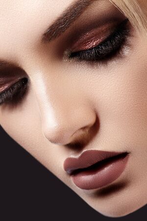 Close-up Portrait of Beautiful Woman Face on dark Background. Fashion Evening Make-up, Glitter Eyeshadows, Matt Lips, Shiny Clean Skin. Sexy Woman Styleの写真素材