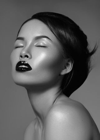 Dramatic black and white fashion portrait of beautiful asian woman. Luxury oriental model with great make-up, smooth skin, gloss lips and perfect hairstyle. Elegant evening lookの写真素材