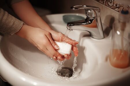 Washing of hands with soap under the crane with water. Hygiene hands in bathroom. Stop virus.の写真素材