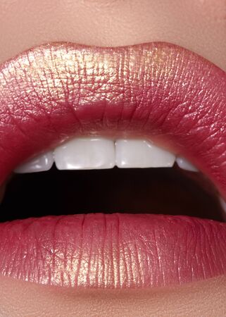Macro close-up glamour fashion bright red lips make-up with gold glitter. Macro of woman's face part. Sexy lip makeup, luxury visageの写真素材