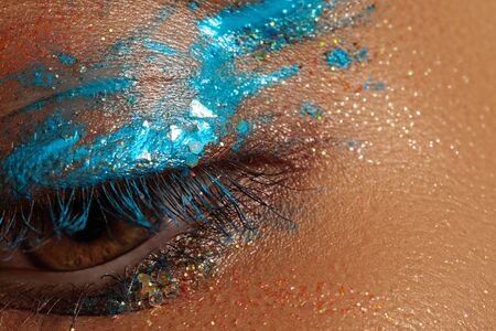 Macro Close-up Creative Art Eye Make-up. Cream Texture Colorful design on female Eye Lid. Beautiful...