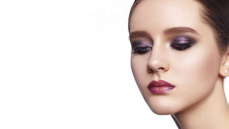 Beautiful Woman with Professional Makeup. Celebrate Style Eye Make-up, Perfect Eyebrows, Shine Skin. Bright Fashion Look. Evening visage with smooth skin and shimmer foundationの写真素材