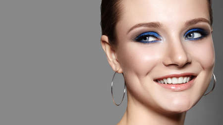 Beautiful Woman with Professional Blue Makeup. Celebrate Style Eye Make-up and Shine Skin. Smiling Fashion Model. Beautifil Happy Smileの写真素材