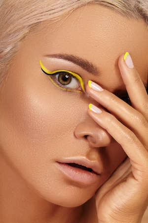 Beautiful close-up portrait of tanned skin woman. Sunburnt girl face with natural boho bronzed make-up and yellow manicure. Sexy summer style makeupの写真素材