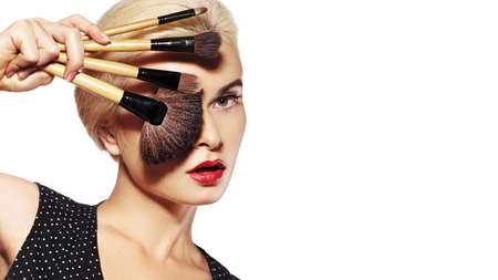 Beauty Treatment. Girl with Makeup Brushes. Fashion Make-up for Sexy Woman. Makeover. Make-up Artist Applying Visage on white background.の写真素材