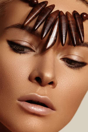 Close-up face of beautiful young woman with smooth tanned skin. Portrait of beauty model with natural bronze make-up. Spa, skincare and wellnessの写真素材