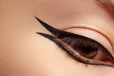 Beautiful macro shot of female eye with classic eyeliner makeup. Perfect shape of eyebrows, brown eyeshadows and long eyelashes. Cosmetics and make-up. Closeup macro shot of fashion liner eyes visageの写真素材