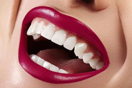 Cropped half face portrait of woman. Closeup Dental Beauty. Beautiful Macro with perfect White Teeth. Sexy Fashion Lips Red Make-up. Whitening Tooth and Wellness Treatmentの写真素材