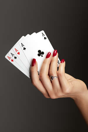 Beautiful glamor photo of elegant female hands with bright burgundy manicure on gray background. Long square nails with dark red gel polish. Luxury fashion style of brilliants jewelry ringsの写真素材