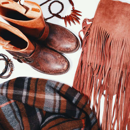 Fashion flat lay with autumnal clothing - scarf, boots, bag, bright wooden accessories. Beautiful cozy trend collection for autumn seasonの写真素材