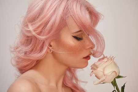 Soft-Girl Style with Trend Pink Flying Hair, Fashion Make-up. Blond Woman Face with Freckles, Blush Rouge, Rose Flowersの写真素材