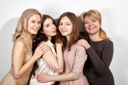 Happy Family of Mother with Three Daughters on Light Grey Background. Fashion Style Studio Portrait.の写真素材