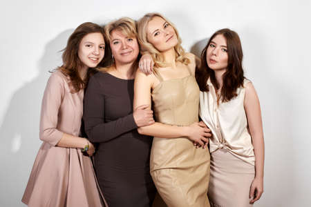 Happy Family of Mother with Three Daughters on Light Grey Background. Fashion Style Studio Portrait.の写真素材