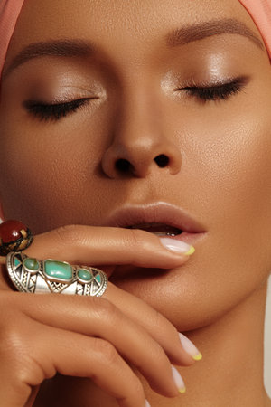 Boho Woman wearing Turban with Bohemian Accessories, Rings, Fashion Make-up. Tan Smooth Skin, Dark Makeup and Manicureの写真素材