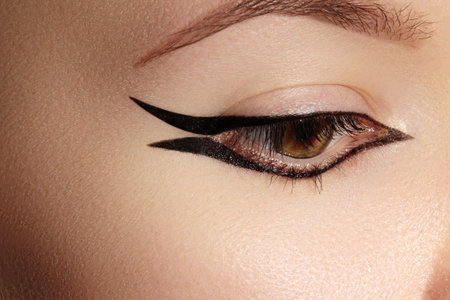 Beautiful Macro Shot of Female Eye with Classic Eyeliner Makeup. Perfect shape of eyebrows. Cosmetics and make-upの写真素材