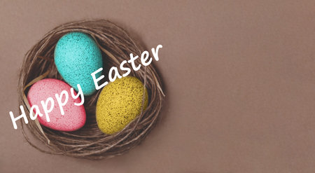 Pastel Speckled Eggs In Twine Nest, Overhead Flatlay On Warm Brown Background Showcasing Pink, Blue,...