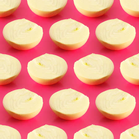 seamless pattern with a slice of onion on a pink background, bright trendy vegetable background for printing on textiles, fabric or paper, for advertising or bannerの写真素材