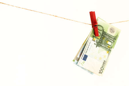 paper euro bills on a red clothespin dry after washing, ladybug on a wooden clothespinの写真素材