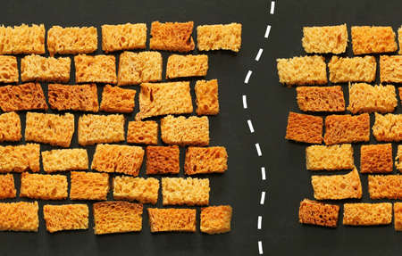 endless wall of rusks, slices of bread laid out like brickwork, passage in the wall with white...