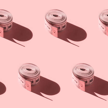 Seamless pattern with a tailor's ruler on a pink background. Endlessly repeating centimeter rolled...