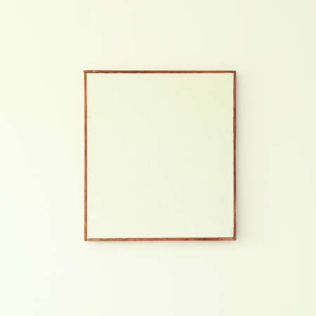 Blank canvas with a simple brutal wood frame on a white plastered wall. Mockup for advertising or painting in a rustic style. Burlap texture in a rough wooden baguette.の写真素材