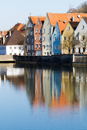 Colorful beautiful city houses on the coast illuminated by the sun. Cityscape Landsberg Am Lech reflected in the river. River Lech, Romantic Road Bavaria Germanyのeditorial素材