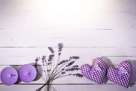 Beautiful hearts with a bouquet of lavender on a wooden background with lavender candlesの写真素材