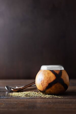 Dried mate tea leaves, high in caffeine, Calabasas and bombilla on a dark wooden backgroundの写真素材