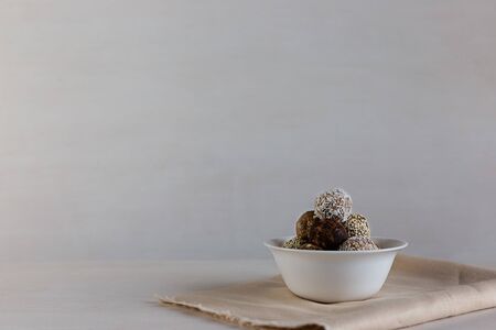 Energy protein balls on a white wooden background. This is a very healthy and delicious product consisting of nuts, dried fruits and peanut paste.の写真素材