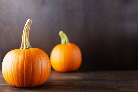 Ripe orange pumpkins on a dark wooden background with copy space.の写真素材