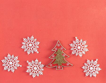 Coral background with decorative Christmas tree and snowflakes. Copy space. Flat lay. Top view.の写真素材