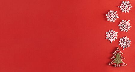 Red background with decorative Christmas tree and snowflakes. Copy space. Flat lay. Top view.の写真素材