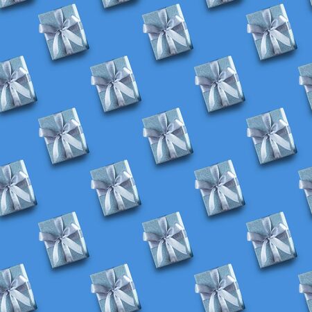 Seamless Christmas pattern with Xmas gift silver box on blue background. Flat lay. Top view.の写真素材