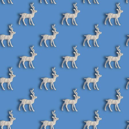Seamless Christmas pattern with Xmas white deer on blue background. Front view.の写真素材