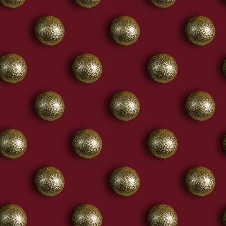 Seamless Christmas pattern with shiny Golden balls on Burgundy background. Flat lay. Top view.