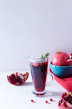 Pomegranate Christmas cocktail with champagne, soda and rosemary on a white table. Xmas drink. Close up. Copy space. Vertical orientation.の写真素材