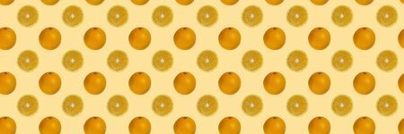 Seamless pattern of a whole and half orange isolated on a light orange table. Food background. Flat lay.の写真素材