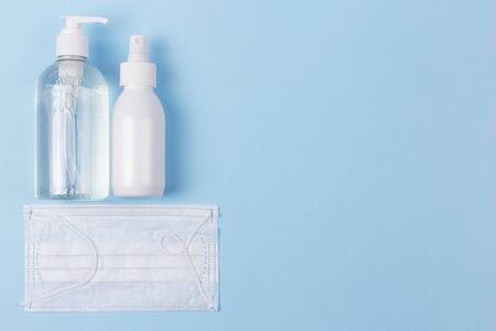 Coronavirus prevention: medical mask, disinfecting gel and hand hygiene spray on a blue background. Protection from coronavirus. COVID-19の写真素材