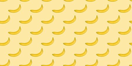 Seamless pattern of bananas isolated on yellow. Food background. Flat lay.の写真素材