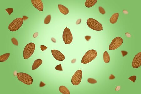 Falling almonds  on a colored background    as package design element and advertising. Flying food. Top view.の写真素材